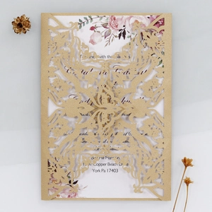 Detail of champagne gold laser-cut floral wedding invitation with elegant card insert