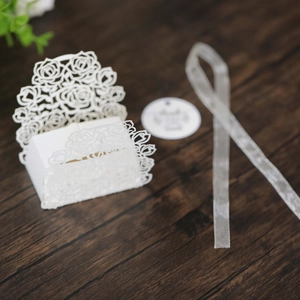 Detail view of white laser-cut rose candy box with silk ribbon and Thank You tag