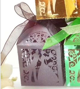 Detailed laser cut wedding favor boxes with bride and groom silhouette and ribbons