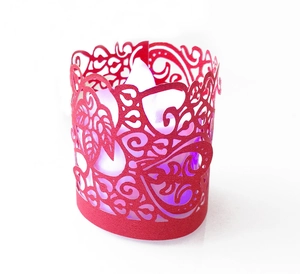 Detail of red laser-cut paper lampshade with floral patterns and purple LED glow