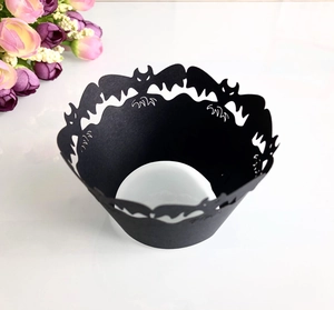 Laser-cut black paper cupcake wrappers with intricate bat silhouettes for Halloween decoration