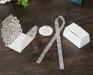Laser-cut rose pattern wedding candy box kit with white cardstock and silver ribbon