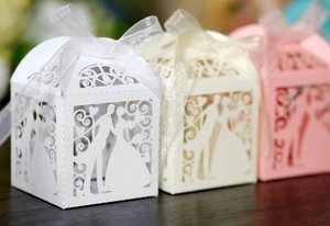 Detailed laser-cut wedding favor boxes with groom and bride silhouette and ribbon bow