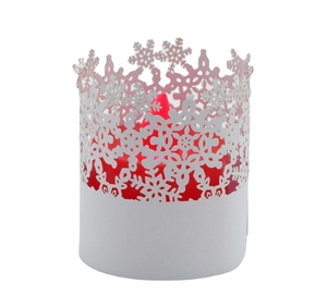 Detail of white laser-cut snowflake paper lantern with a red pillar candle inside