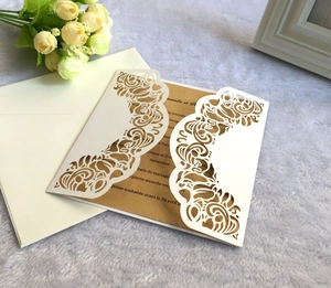 Détail de l'invitation de mariage découpée au laser avec insert doré et enveloppe blanche