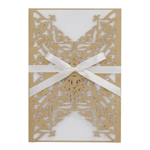 Detailed laser-cut floral pattern on champagne wedding invitation with white ribbon