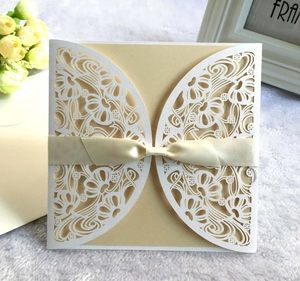 Elegante lasergeschnittene Hochzeitseinladung mit weißer Spitze und beige Schleife