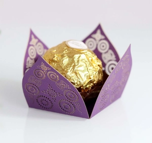 Macro view of purple laser-cut flower pattern chocolate wrapper for wedding favors