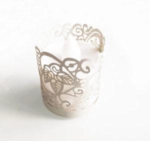 Detail of white laser-cut leaf pattern paper lampshade with a flameless LED candle inside
