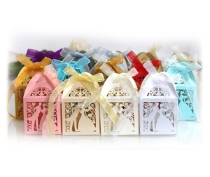 Laser-cut wedding favor boxes with ribbon bows shown in various pearlescent colors