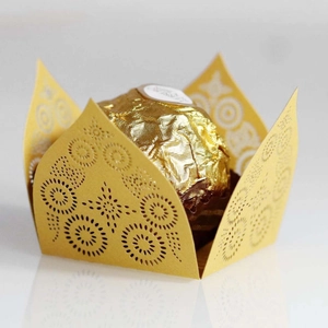 Macro detail of laser-cut gold paper chocolate wrapper with intricate star patterns