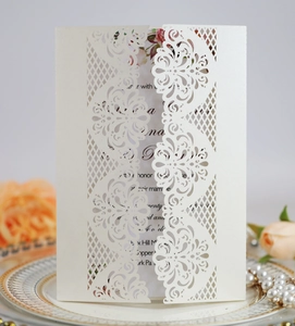Close-up of laser-cut damascus floral invitation card in cream pearlescent paper