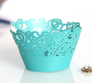 Macro view of Tiffany blue laser-cut cupcake wrapper with intricate vine patterns