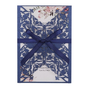 Laser-cut champagne floral wedding invitation with navy blue hollow cover and ribbon bow