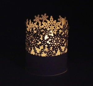 Detailed view of snowflake laser-cut paper lampshade with warm LED candle light effect