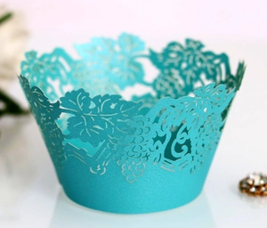 Macro view of laser-cut grape vine pattern on pearlescent cyan cupcake wrapper