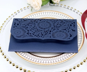 Dettaglio dell'intaglio laser floreale blu navy su carta perlata per inviti