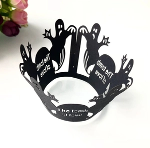 Detail of laser-cut black spider web cupcake wrappers with ghost and text patterns