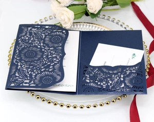 Dettaglio dell'invito di nozze blu marino con intaglio laser e motivi floreali mandala