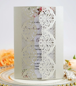 Detailed laser-cut floral pattern on silver pearlescent paper wedding invitation