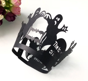 Macro detail of laser-cut black Halloween cupcake wrappers featuring ghosts and bats
