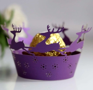 Detail of laser-cut purple Christmas cake wrapper with reindeer and snowflake patterns