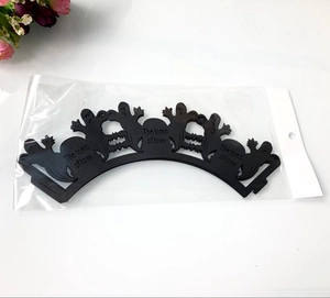Close-up of laser-cut black Halloween cupcake wrappers featuring ghost and bat designs