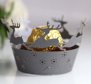 Macro view of laser-cut grey cupcake wrapper featuring reindeer and snowflake patterns