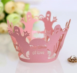 Macro detail of laser-cut pink pearlescent paper cupcake wrapper with ghost design