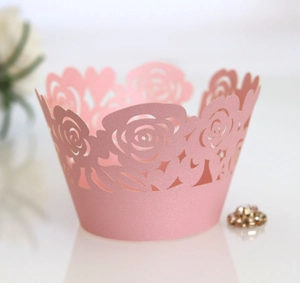 Detailed laser-cut rose floral pattern on pink cupcake wrappers for wedding parties