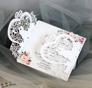 Macro detail of laser-cut wedding invitation featuring romantic silhouette on soft tulle