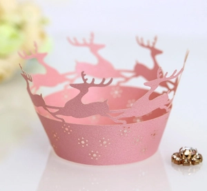 Macro view of pink laser-cut reindeer and snowflake Christmas cupcake wrappers