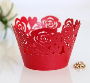 Close-up of laser-cut red rose cupcake wrappers with heart-shaped patterns for parties