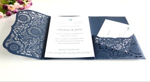 Dettaglio dell'invito di nozze blu navy intagliato al laser con motivi floreali