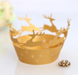 Macro shot of gold laser-cut reindeer and snowflake hollow pattern on cupcake wrappers