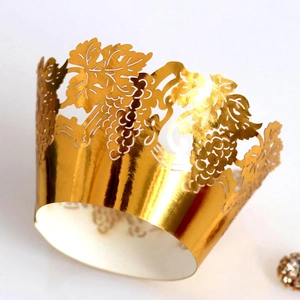 Laser-cut gold metallic cupcake wrappers with intricate grape vine patterns for decoration