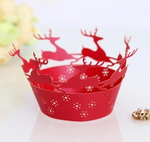 Close-up of red laser-cut cupcake wrappers with reindeer and snowflake patterns