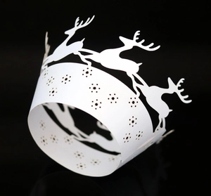 Macro detail of laser-cut white paper cupcake wrappers with reindeer and star patterns