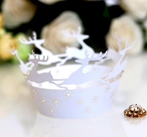 Macro shot of white laser-cut reindeer and snowflake cupcake wrapper for festive decoration