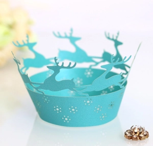 Macro shot of laser-cut light blue cupcake wrapper with reindeer and snowflake design