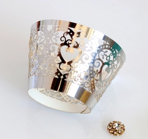Laser-cut silver metallic cupcake wrapper with elegant heart pattern for wedding decor