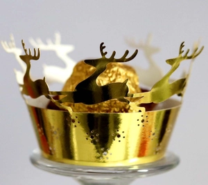 Close-up of golden laser-cut Christmas cupcake wrappers with reindeer patterns