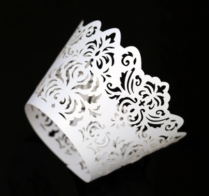 Macro shot of white laser-cut floral cupcake wrappers with pearlescent crown finish