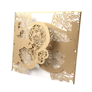 Detail of laser-cut gold wedding invitation cover with elegant floral lace pattern
