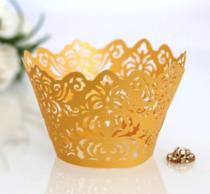 Close-up of golden laser-cut cupcake wrapper with intricate floral lace patterns
