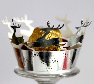 Close-up of silver laser-cut cupcake wrapper with reindeer and star patterns for Christmas