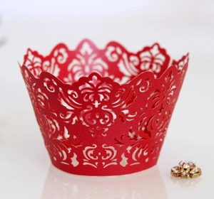 Macro shot of red laser-cut cupcake wrapper with intricate floral hollow patterns