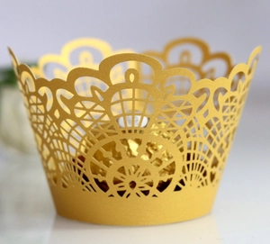 Macro shot of laser-cut gold lace cake wrapper with intricate floral patterns and truffle