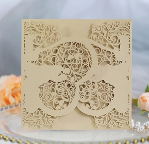 Close-up of laser-cut wedding invitation cover with champagne gold pearl finish