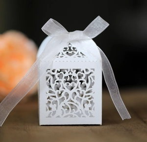 Macro detail of white laser-cut hollow heart gift box with elegant organza ribbon